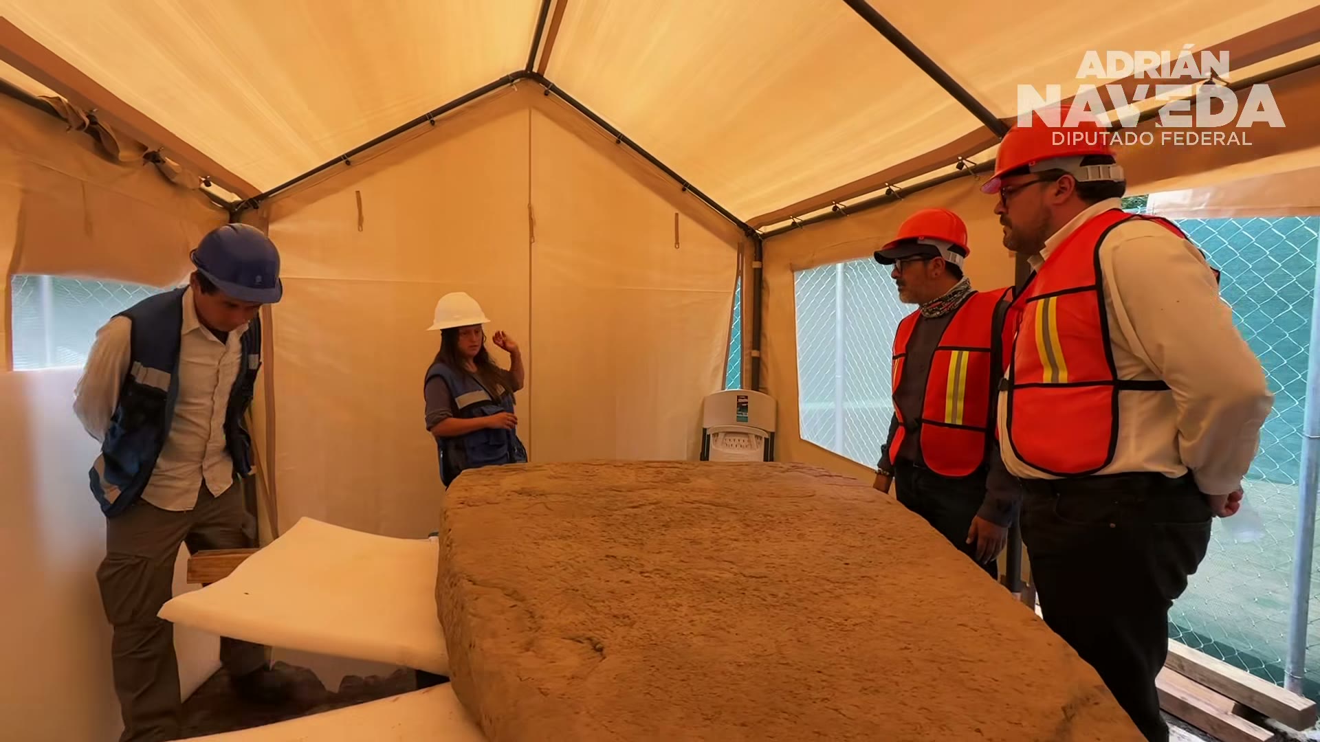 La Estela Coatepec, resguardada en sitio, examinada por el equipo de arqueólogos.